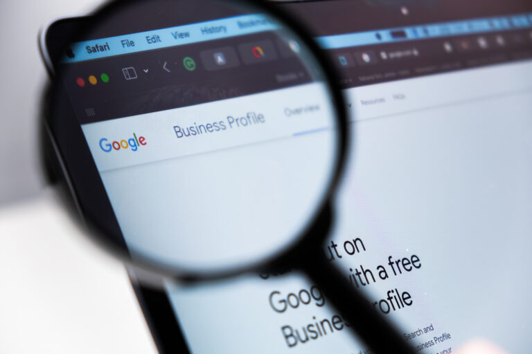 google business profile logo enlarged through a magnifying glass on a laptop screen