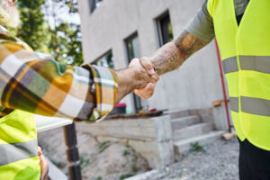Construction workers shaking hands on site