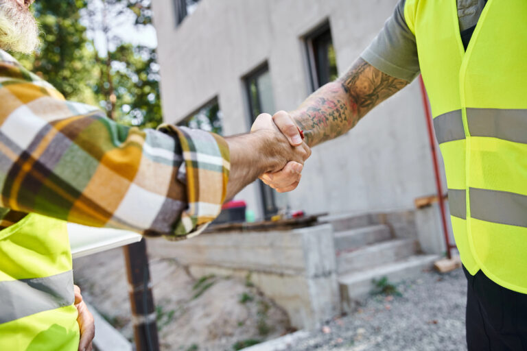 Construction workers shaking hands on site